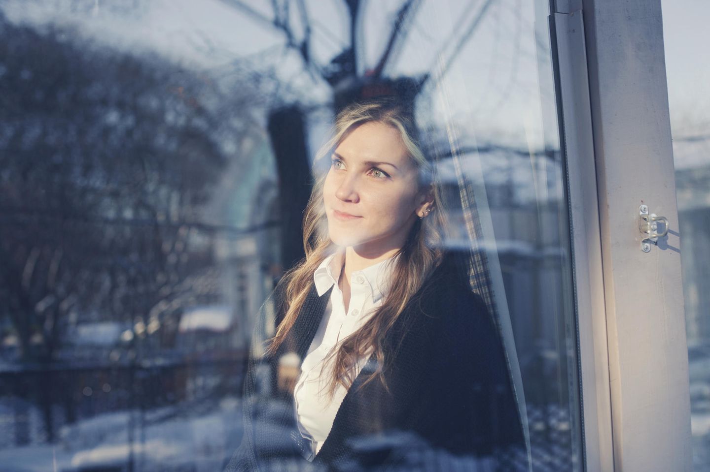 Mit Mitte 30 das Leben ändern: Nachdenkliche junge Frau am Fenster