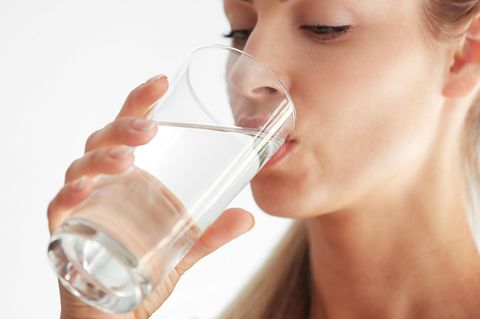 Schluckauf: Frau trinkt Wasser aus einem Glas