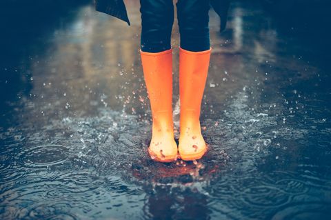 Durchblutung fördern: Frau mit Gummistiefeln im Regen