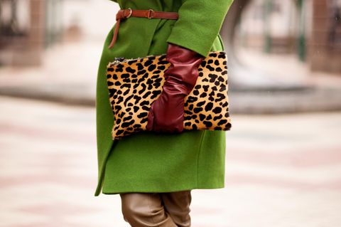 Herbst-Accessoires: Frau mit grünem Mantel und Leo-Tasche