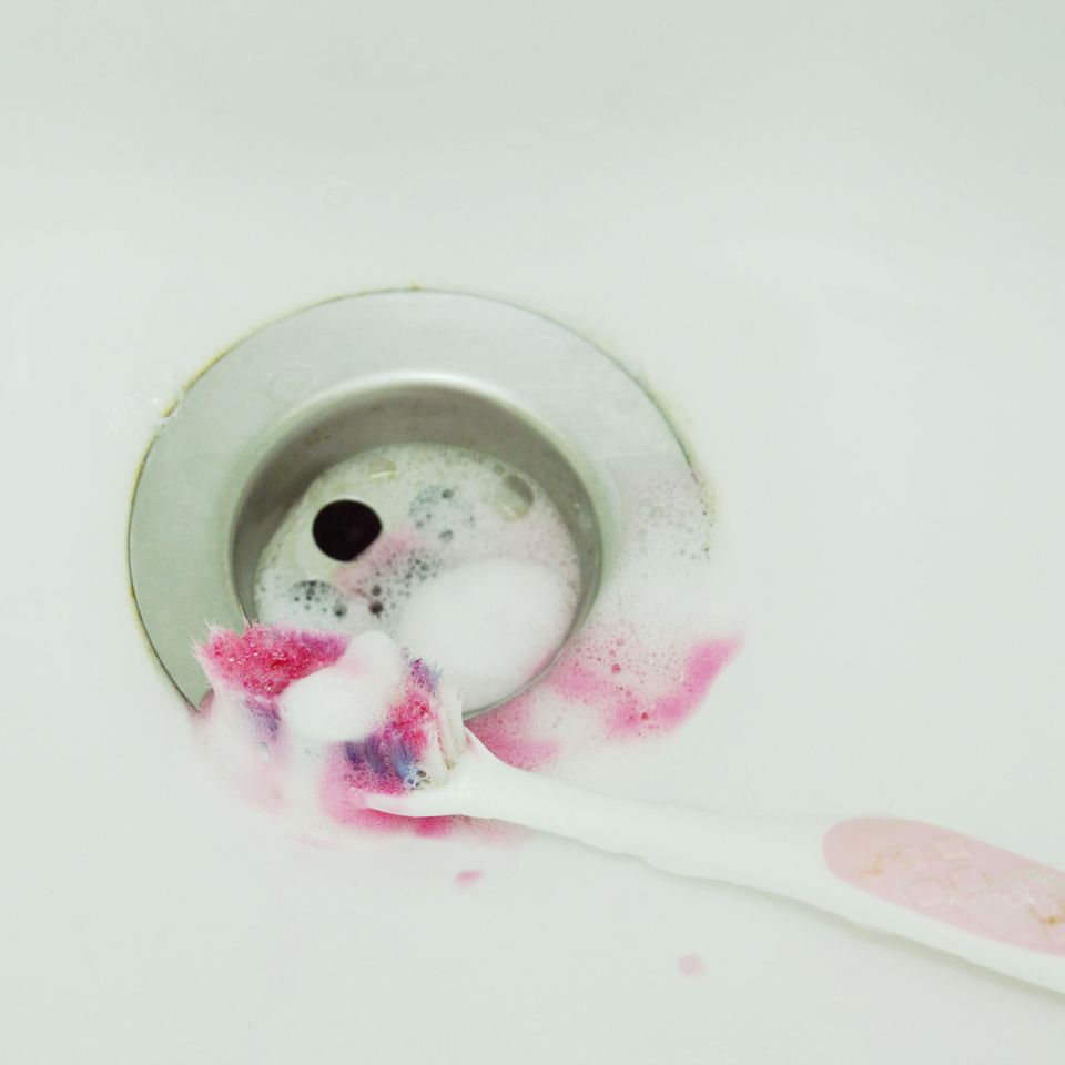 Zahnfleischbluten: Zahnbrüste mit Blut im Waschbecken