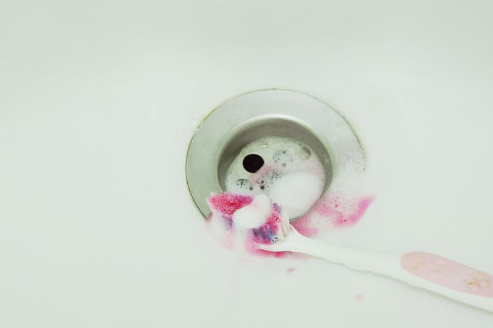 Zahnfleischbluten: Zahnbrüste mit Blut im Waschbecken