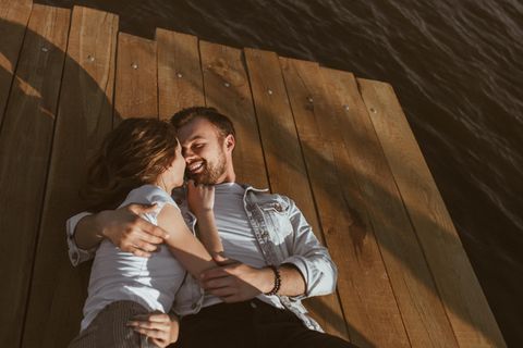 Wahre Liebe: Ein junger Mann hält die Hände seiner Frau mit beiden Händen und küsst sie liebevoll