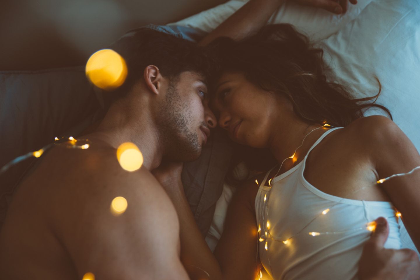 Sex an Weihnachten: Paar liegt mit Lichterketten im Bett