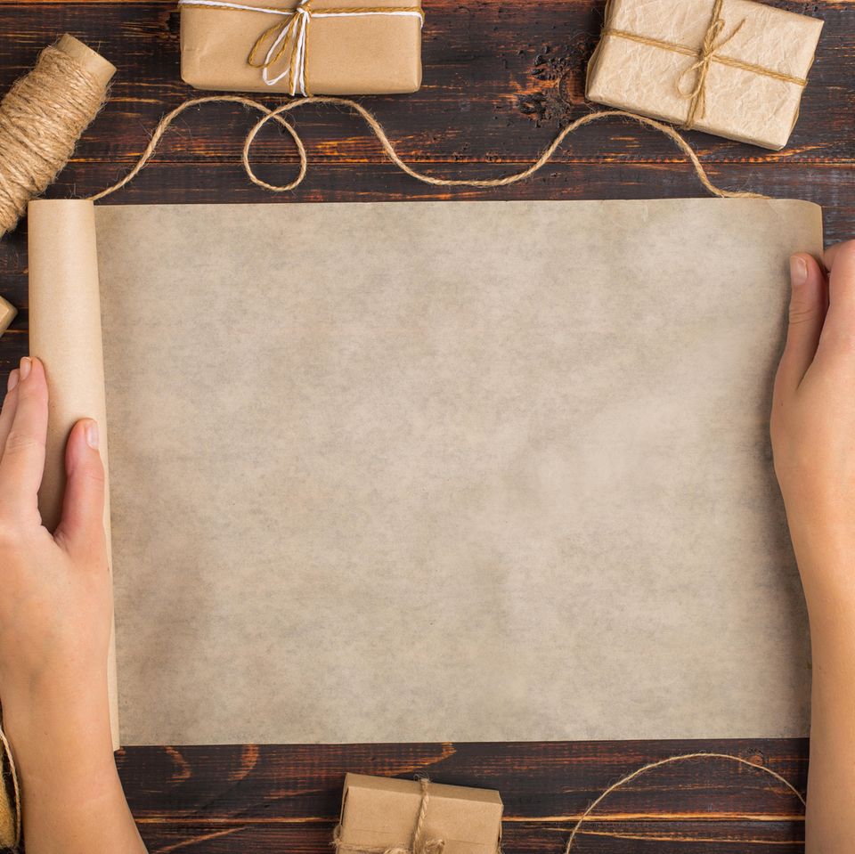 Geschenkpapier selber machen: Frau breitet Packpapier aus