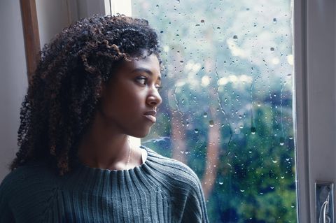 Sehnsucht nach Liebe: Eine junge blickt auf dem Fenster