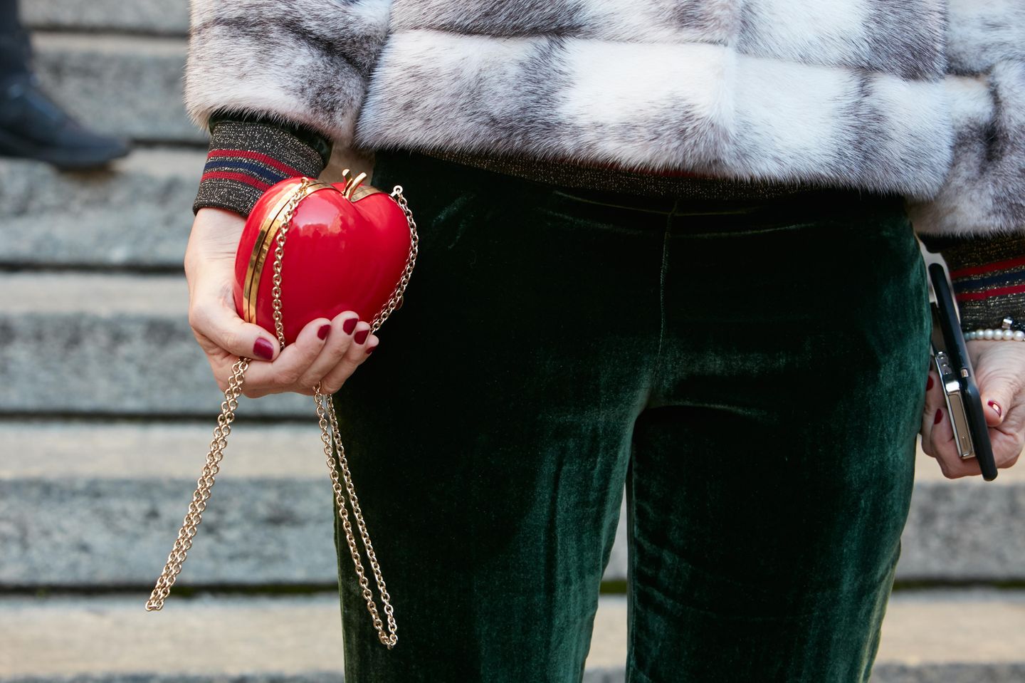 Herbsttrend Samt: Frau mit Samthose und roter Apfel-Tasche