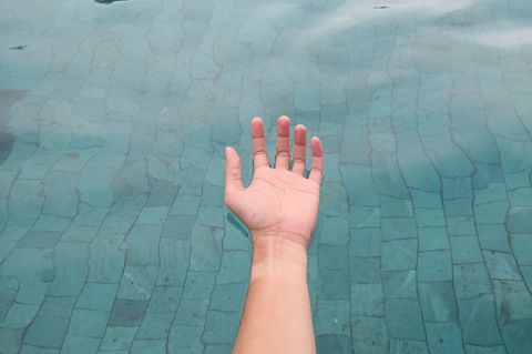 Floating: Eine Hand treibt auf der Wasseroberfläche