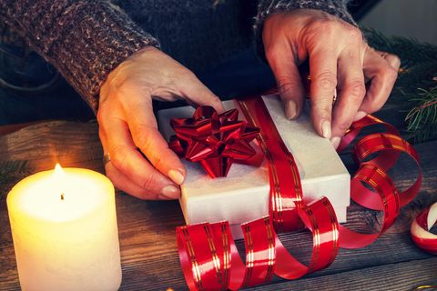 Weihnachtsgeschenke für die Mutter: Frau hält Geschenk in den Händen