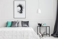 Große Bilder an der Wand wirken teurer Wohnung teurer wirken lassen: Großes Bild hängt über weißem Bett