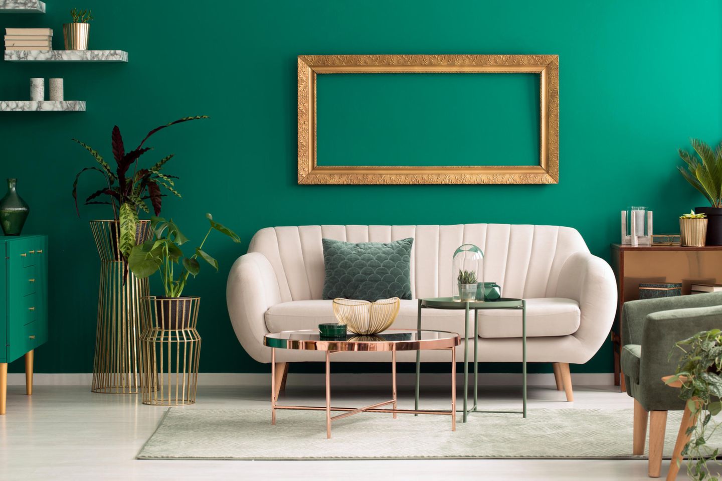 Wohnung teurer wirken lassen: Weiße Couch, smaragdgrüne Wand, Dekoelemente