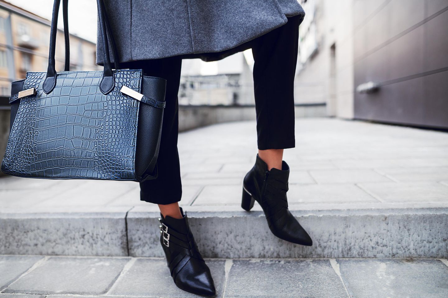 5 Looks, die wir im Dezember nachstylen: Frau mit Ankle Boots und Handtasche