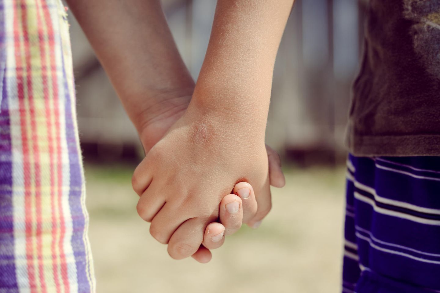 Gericht entzieht zwei Kindern ihren Nachnamen: Kinder halten Händchen