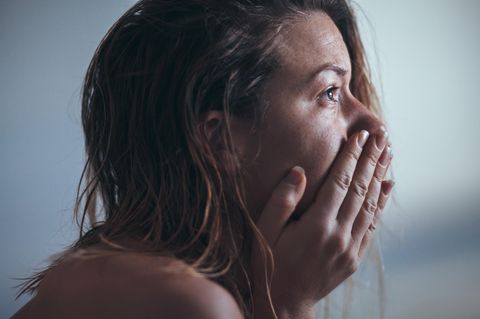 5 Phasen der Trauer: Frau schlägt Hände vor das Gesicht