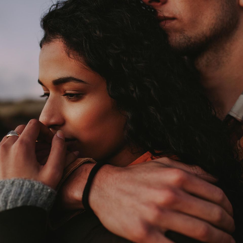 Gefühle, die du nicht mit Liebe verwechseln solltest: Nachdenkliche Frau von Mann umarmt