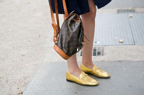 Festliche Schuhe ohne Absatz: Frau trägt Goldene Loafer