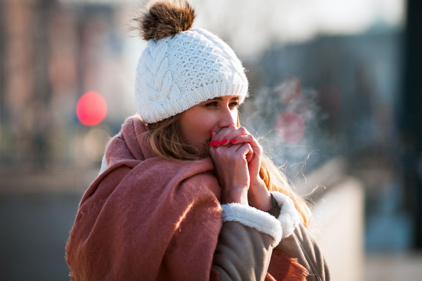 Kälte verschlimmert Krankheiten: Frau friert draußen in der Kälte