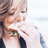 Das Brigitte-Balance Konzept: Frau beißt in Sandwich