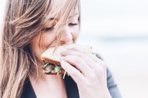 Das Brigitte-Balance Konzept: Frau beißt in Sandwich