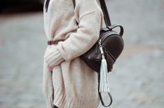 Fashion Basics 2019: Woman with knitted cardigan and backpack "loading =" lazy