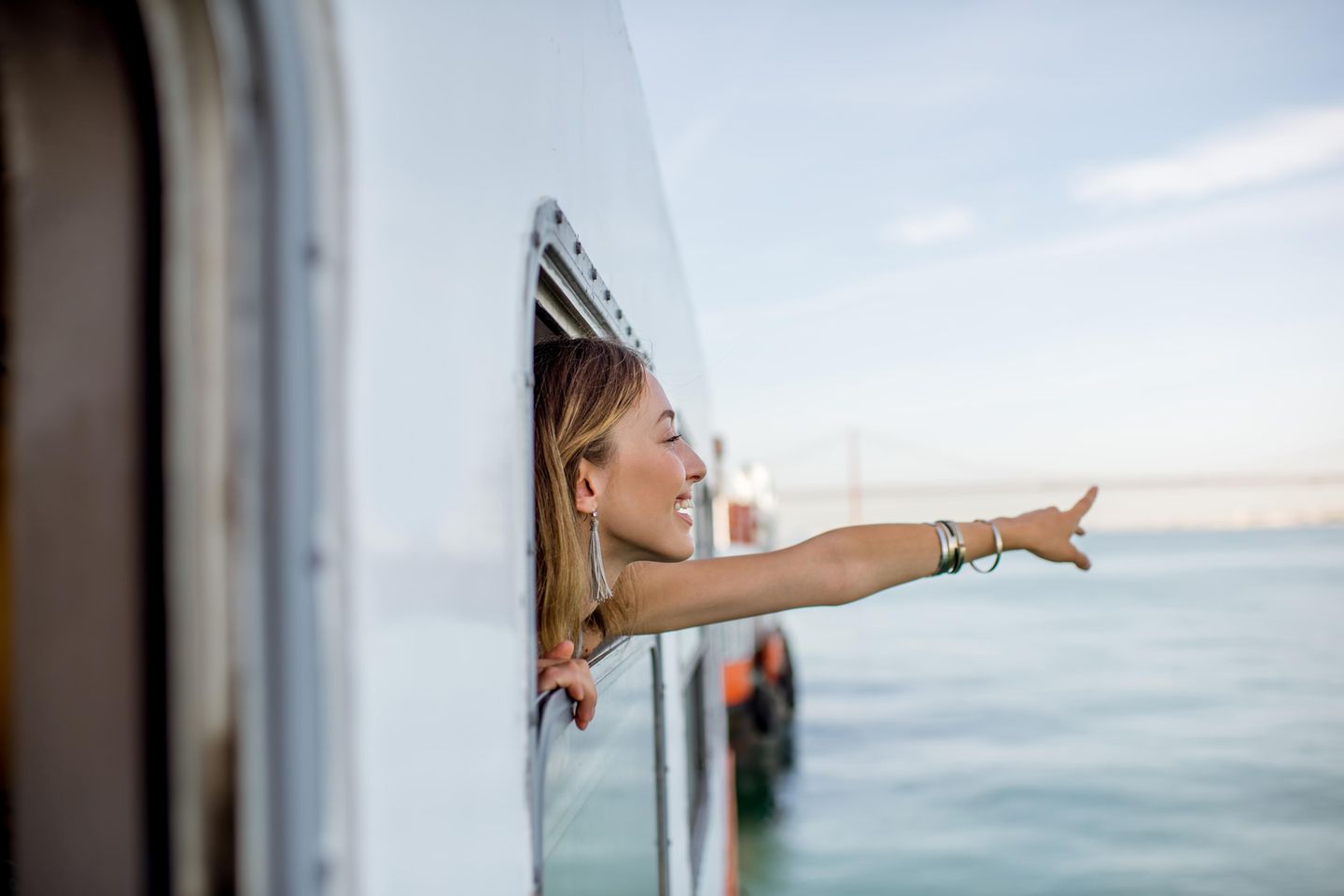 Emotionale Intelligenz: Eine junge Frau auf einem Schiff zeigt auf den Ozean