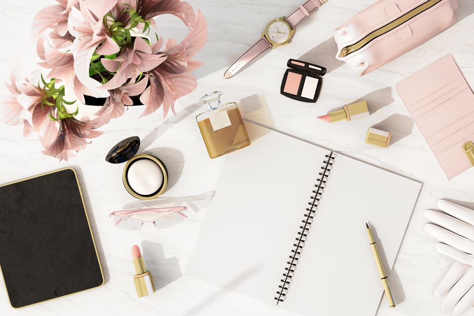 Büro-Essentials: Schreibtisch mit Notizheft, Lippenstift, Puder und Lidschatten