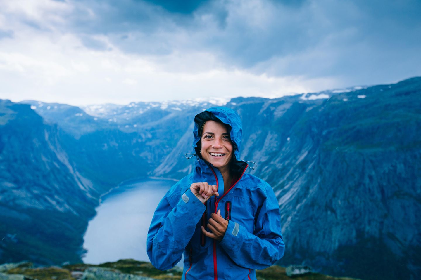 Regenjacke imprägnieren – mit diesen Tipps klappt's! Frau steht in Regenjacke vor einer Berglandschaft