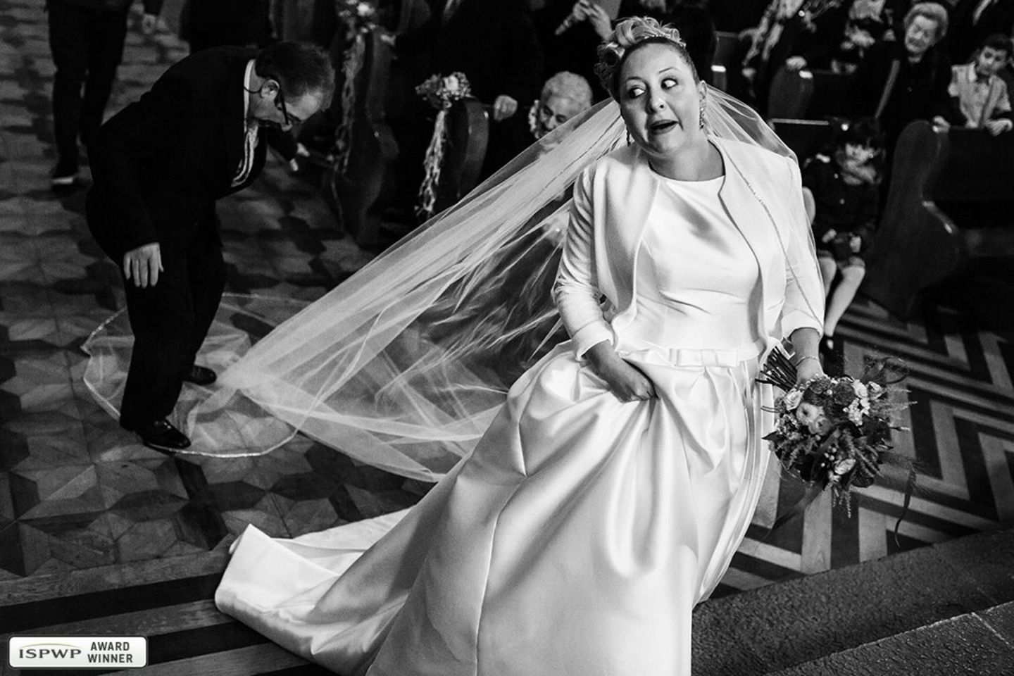 Hochzeitsfotos 2019: Die schönsten Bilder: Ein Mann tritt der Braut auf den Schleier