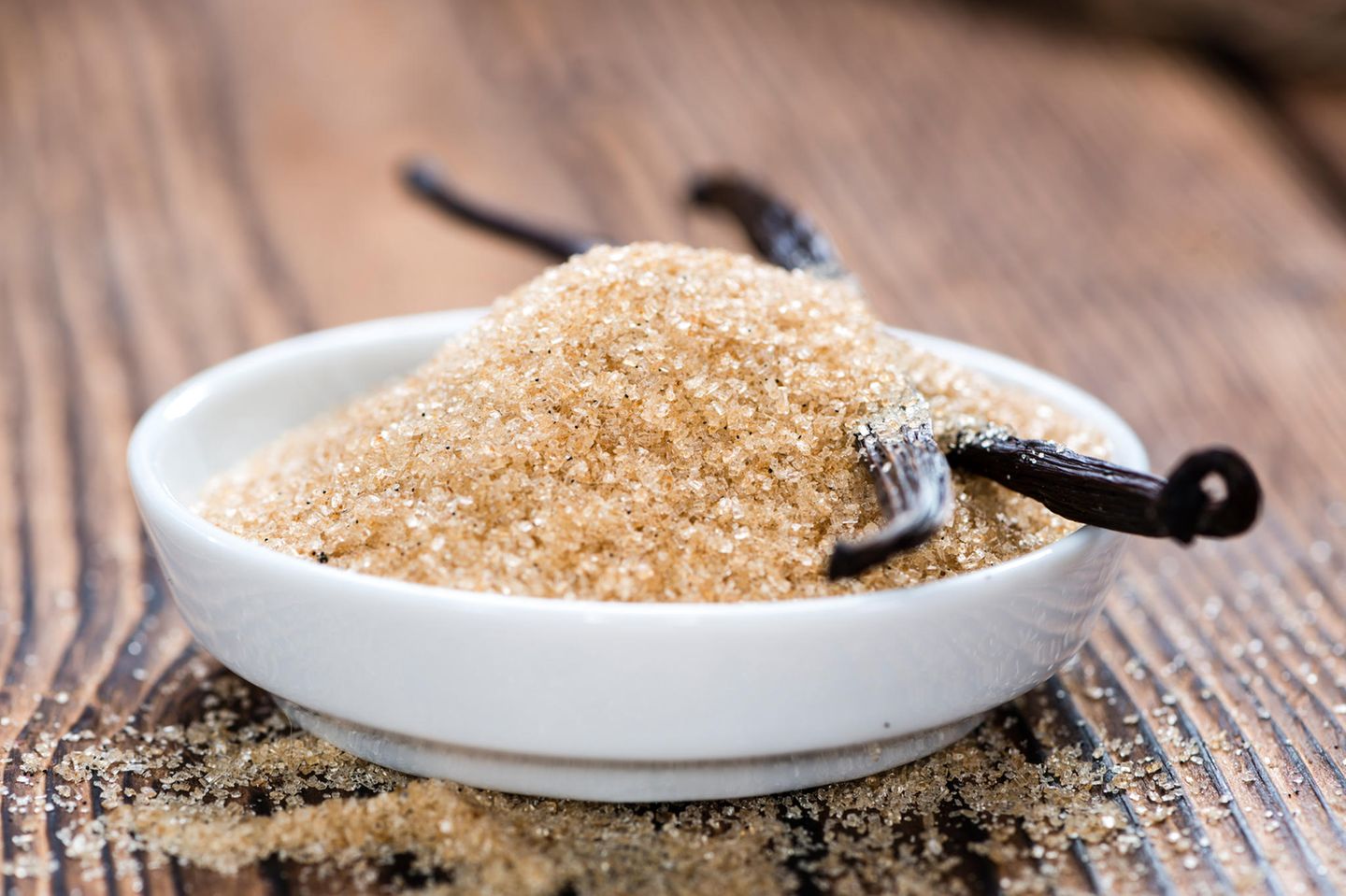 Vanillezucker selber machen – schnell und einfach: Eine Schale mit braunem Zucker und zwei Vanilleschoten steht auf dem Tisch