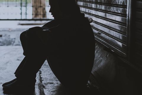 Obdachlos - und keiner weiß es: Frau sitzt im Schatten auf der Straße