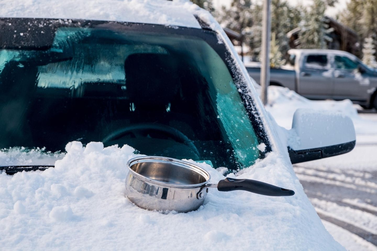 Tipps bei Kälte: Eingeschneites Auto mit Topf auf der Motorhaube