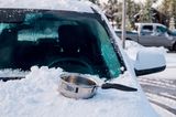 Tipps bei Kälte: Eingeschneites Auto mit Topf auf der Motorhaube
