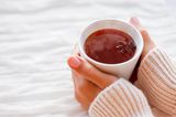 Tipps bei Kälte: Eine Frau hält eine heiße Tasse Tee in den Händen