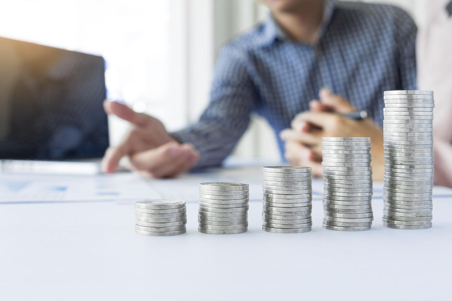 Gehaltserhöhung: Gestapelte Geldmünzen auf Schreibtisch