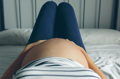 Risikochwangerschaft: Schwangere Frau liegt auf Bett