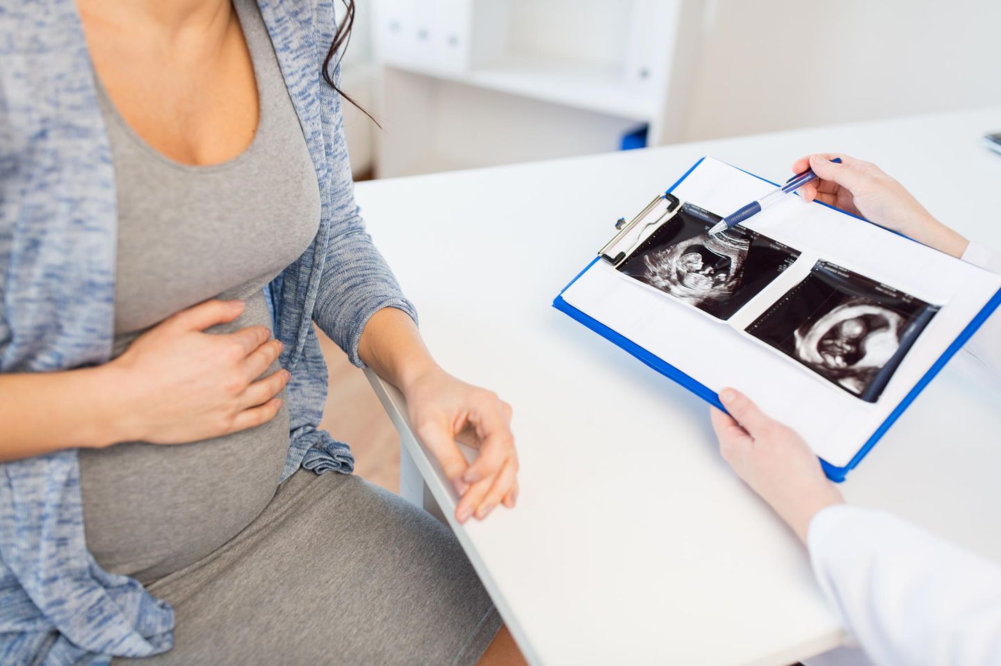 Pränataldiagnostik: Arzt erklärt schwangerer Frau Ultraschallbild
