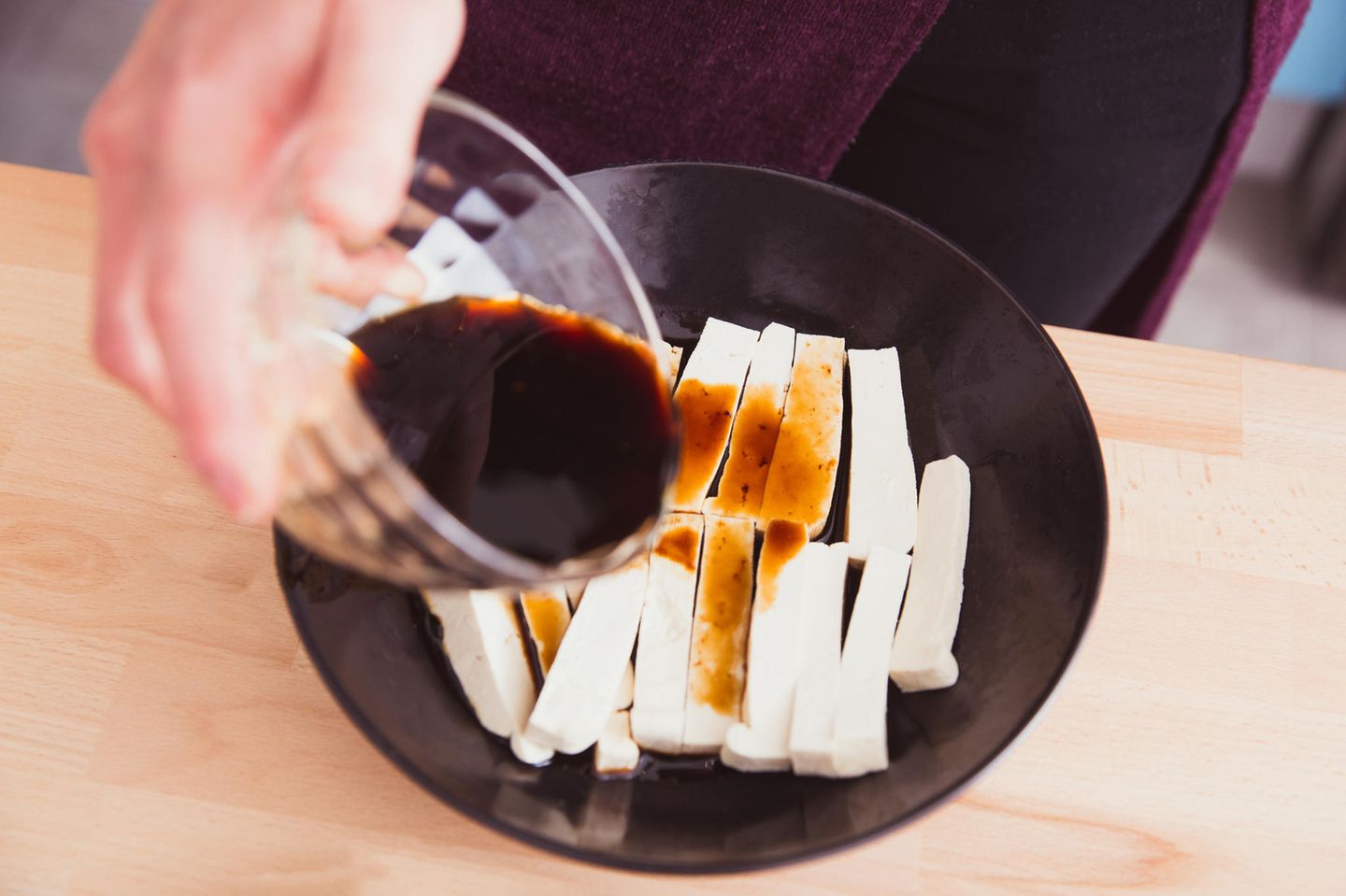 Tofu marinieren: 3 leckere Variationen: Schale mit geschnittenem Tofu über die Sojasauce gegossen wird