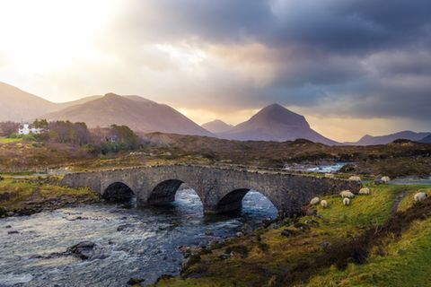 Coorie: Gemütlichkeit auf schottisch: Berge in Schottland, davor ein Fluss mit einer Steinbrücke