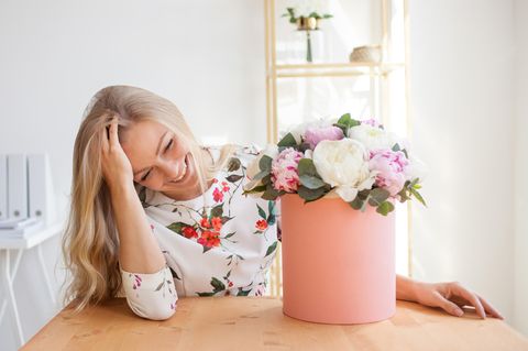 Valentinstagsgeschenke, die wir uns selber machen: Frau vor einer Vase mit Blumen