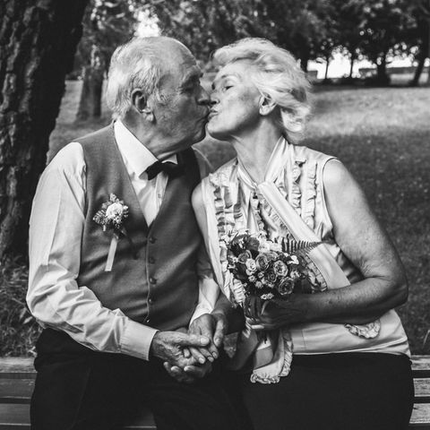 Diamantene Hochzeit: Gedichte und Geschenkideen zum Jubiläum: Senioren-Ehepaar sitzt auf einer Parkbank und küsst sich