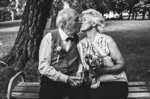 Diamantene Hochzeit: Gedichte und Geschenkideen zum Jubiläum: Senioren-Ehepaar sitzt auf einer Parkbank und küsst sich