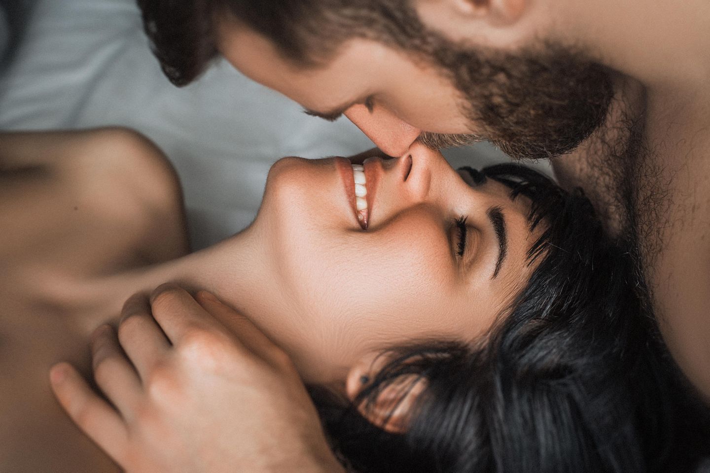 Was ist der Unterschied zwischen Sex haben und Liebe machen? Ein glückliches Pärchen im Bett