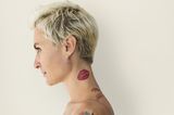 Tattoo Motive: Eine Frau mit einem Kussabdruck-Tattoo auf dem Hals