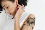 Tattoo Motive: Eine Frau mit einem Fuchs-Tattoo auf dem Oberarm