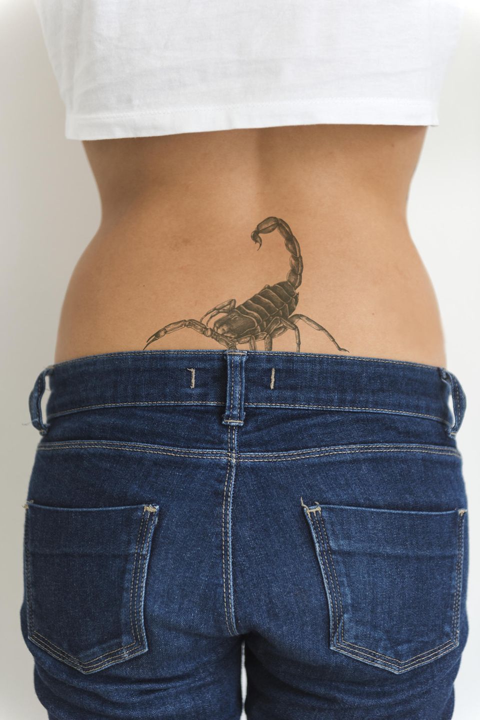 Tattoo Motive: Eine Frau mit einem Skorpion-Tattoo am Steißbein
