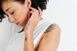 Tattoo Motive: Eine Frau mit Schriftzug-Tattoo an der Handaußenseite