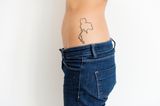 Tattoo Motive: Eine Frau mit einem Land-Tattoo auf der Hüfte