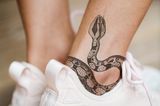Tattoo Motive: Eine Frau mit Schlangen-Tattoo am Knöchel