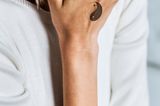 Tattoo Motive: Eine Frau mit Yin-Yang-Symbol auf dem Handrücken