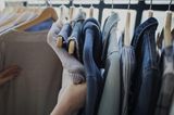 Zeitfresser loswerden: Eine Frau nimmt sich Klamotten von der Kleiderstange